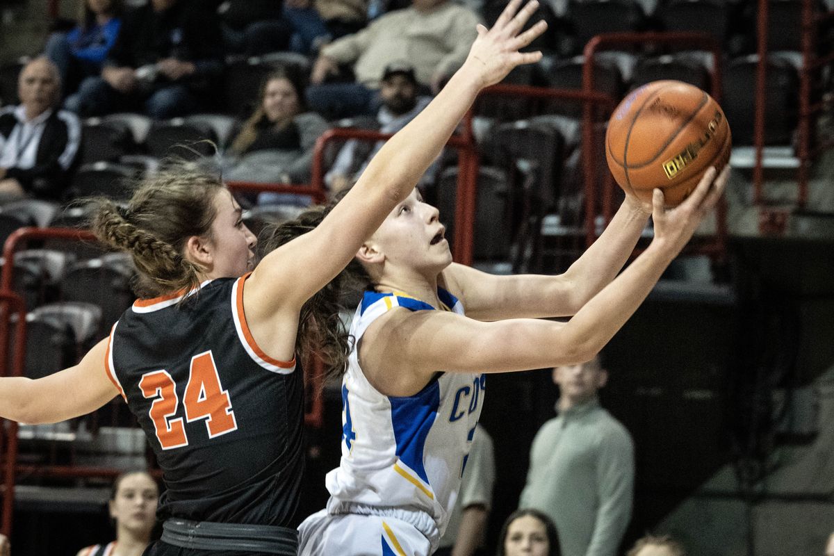 Colfax post Hailey Demler (24) heads to the basket as Rainier forward Bryn Beckman (24) defends during a WIAA State B Basketball 2B girls quarterfinal, Thursday, March 2, 2023, in the Spokane Veterans Arena.  (COLIN MULVANY/THE SPOKESMAN-REVIEW)