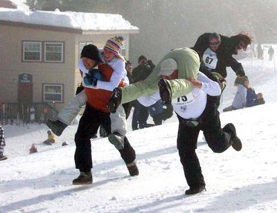 Previous contestants at the Lookout Pass Ski Area wife-carrying contest demonstrate the “Estonian technique,” foreground, in which the wife hangs upside down.