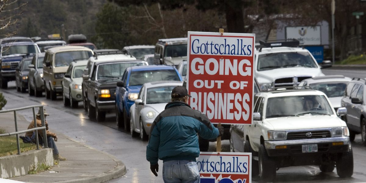 A man holds a going-out-of-business sign in Bend, Ore.  (File Associated Press / The Spokesman-Review)