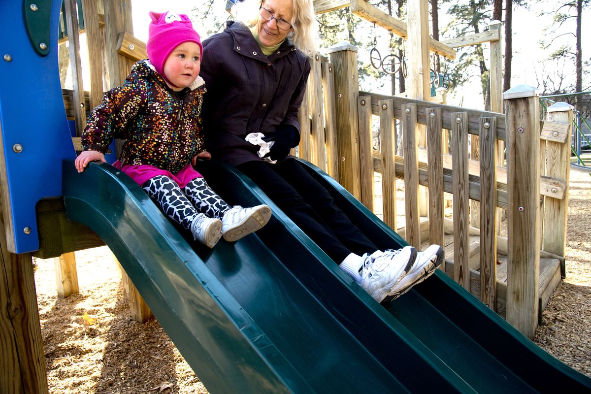 Kyla Tobler, 2, prepares to go down a slide with her grandmother, Morag Stewart, at Coeur d’Alene Park, on Dec. 3. The neighborhood council and Friends of Coeur d’Alene Park are gathering ideas about improvements in the park. (Jesse Tinsley)