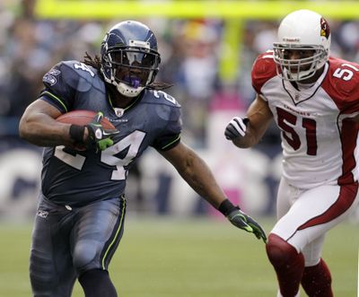 Seattle Seahawks' Marshawn Lynch (24) runs as Arizona Cardinals' Paris Lenon, right, gives chase in the second half of an NFL football game, Sunday, Oct. 24, 2010, in Seattle. (Elaine Thompson / Associated Press)