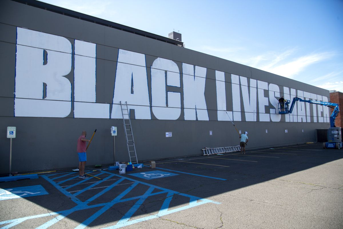 Personnel from the Seven2 and 14Four digital advertising agencies prime the side of their building with “Black Lives Matter,” which will be the canvas for 16 individual artists who will fill in each letter in their own style over the next few weeks. The building is at 244 W. Main Ave. in downtown Spokane.  (JESSE TINSLEY)