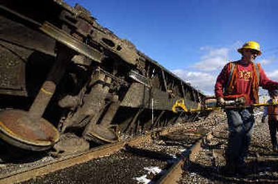 
Rob Henderson removes a hydraulic surger, a tool used to repair railroad tracks, from the scene of a derailed log car in Mica on Thursday morning. Road sand had filled in the track at a crossing and derailed the car. 
 (Jed Conklin / The Spokesman-Review)