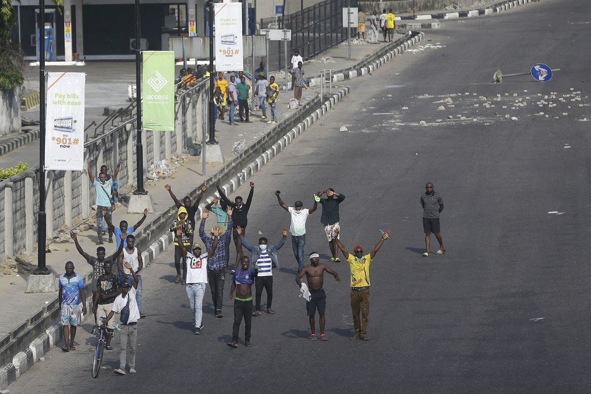 People demonstrate on the street to protest against police brutality in Lagos, Nigeria, Wednesday Oct. 21, 2020. After 13 days of protests against alleged police brutality, authorities have imposed a 24-hour curfew in Lagos, Nigeria