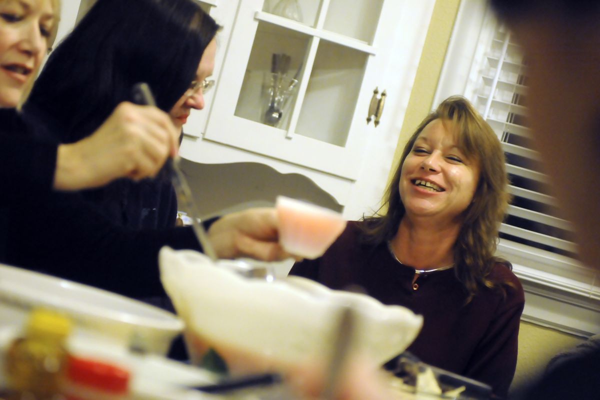 Kitty Coleman, right, a resident of Miryam’s House, laughs during dinner last week. Mealtime is an important part of the recovery process offered at Miryam’s.  (Jesse Tinsley)