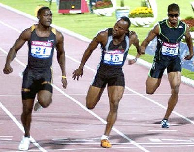 
Justin Gatlin of the United States, left, crosses the finish line to break the men's 100-meter world record at the Qatar Grand Prix. 
 (Associated Press / The Spokesman-Review)