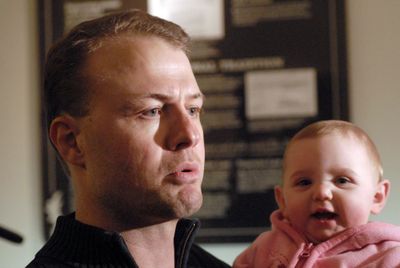 Tim Eyman, holding 8-month-old daughter Riley, talks to reporters in Olympia about his new ballot measure Monday.  (RICHARD ROESLER / The Spokesman-Review)