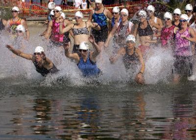 
Swimmers in the 30- to-34-year-old division charge into Liberty Lake for the start of the Valley Girl Triathlon on Sunday. 
 (Photos by J. Bart Rayniak / The Spokesman-Review)