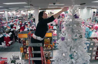 
Shevonne Brown decorates a Christmas tree at the NorthTown Kohl's, which is holding its grand opening  today. 
 (Dan Pelle / The Spokesman-Review)