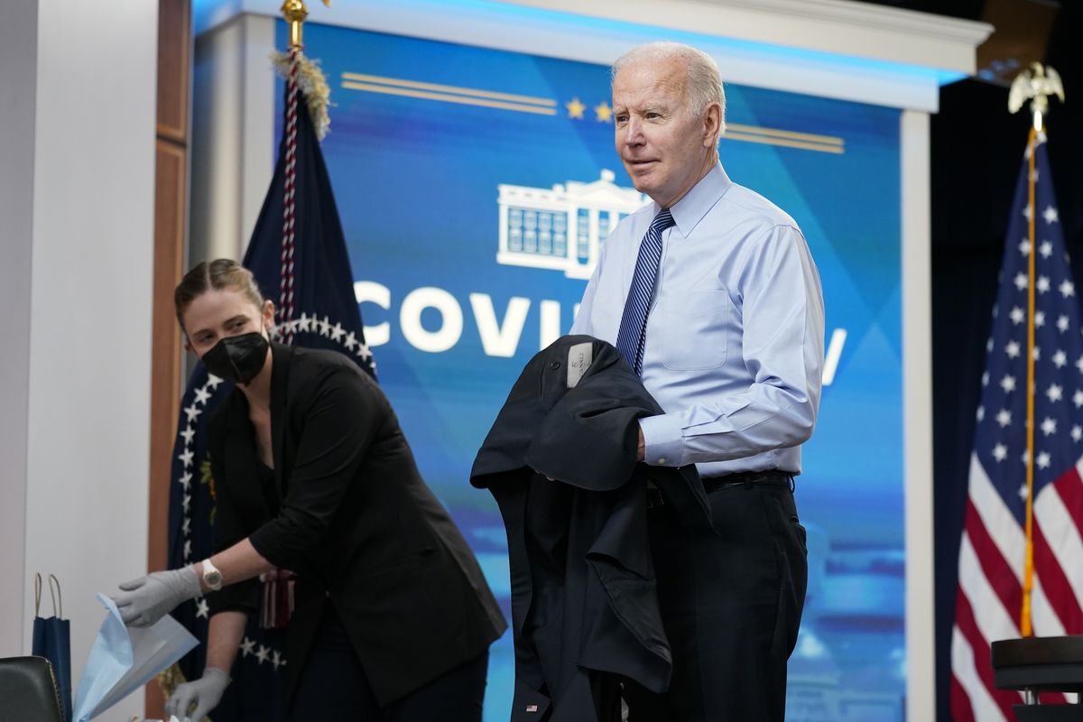 President Joe Biden removes his jacket before receiving his second COVID-19 booster shot in the South Court Auditorium on the White House campus, Wednesday, March 30, 2022, in Washington.  (Patrick Semansky)