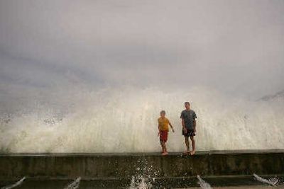
Caleb Holcomb, 14, left, and Adam Stewart, 17, of Mobile, Ala., play along the Perdido Pass seawall Friday in Orange Beach, Ala. 
 (Associated Press / The Spokesman-Review)