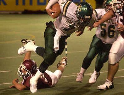 
Shadle Park quarterback Josh Powell is tripped up by North Central defensive back Devon Cox in the second quarter Friday at Albi Stadium.
 (Brian Plonka / The Spokesman-Review)