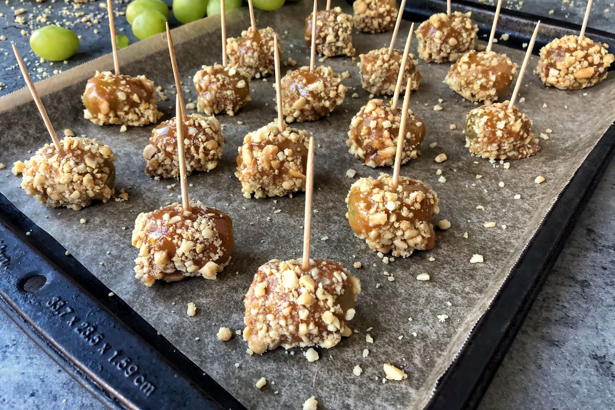 This alcohol-soaked treat calls for only four ingredients: grapes, vodka, caramel and peanuts, plus toothpicks.  (Audrey Alfaro/For The Spokesman-Review)