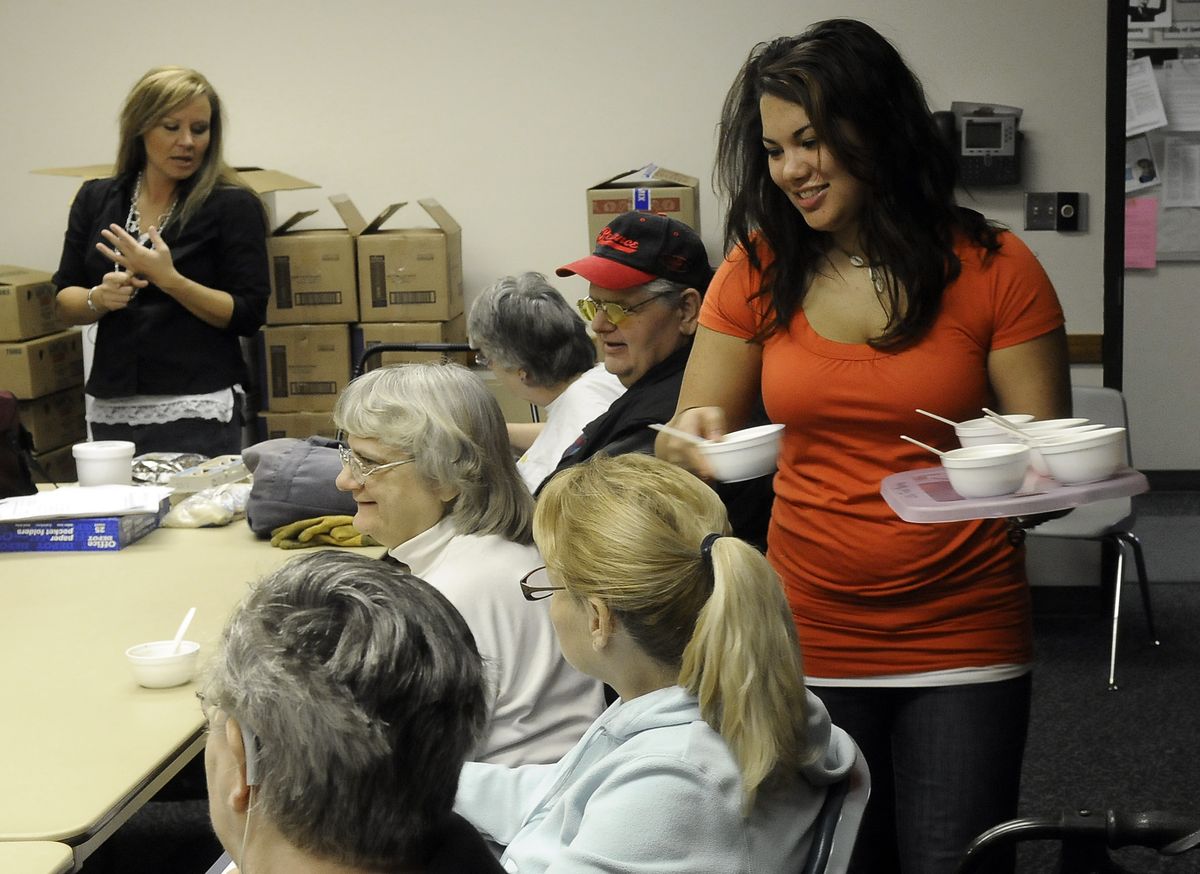 Brandi Anderson, left, of the WSU Spokane County Extension “Food $ense” program talks with the class about nutrition and recipes as Sam Kern passes out cups of rice pudding at the East Central Community Center. The Spokesman- Review (DAN PELLE The Spokesman- Review / The Spokesman-Review)