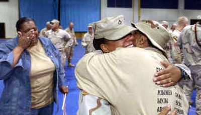 
Washington National Guard Pfc. ReJeana Gordon, of Tacoma, center, hugs her grandmother Mildred Farrow of Lakewood, Wash., while her mother, Cyntha Gordon, of Tacoma, tears up Thursday at Fort Lewis.
 (Associated Press / The Spokesman-Review)