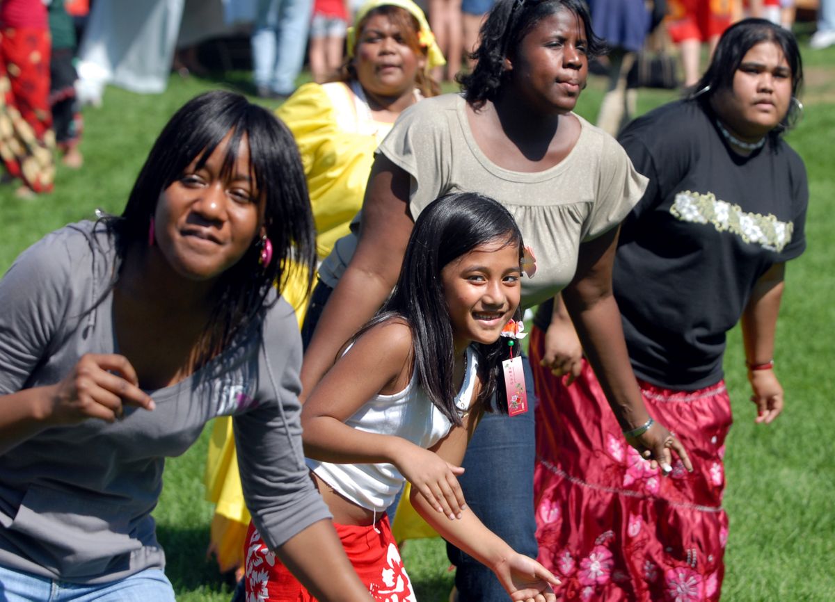 Janet Samewell, 8, who is Micronesian, dances with Tere Graham, left, and Kerra Bower, behind Samewell, and dancers of various ethnicities while doing the “Electric Slide”  at the Unity in the Community festival Saturday in Riverfront Park.  (Photos by Jesse Tinsley / The Spokesman-Review)