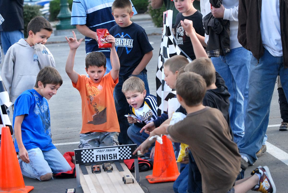 Boys cheer at the end of the Pinewood Derby track at the Cub Scout kick-off event, Race to Cub Scouting Rally held Friday in the Spokane Arena parking lot. (Jesse Tinsley / The Spokesman-Review)