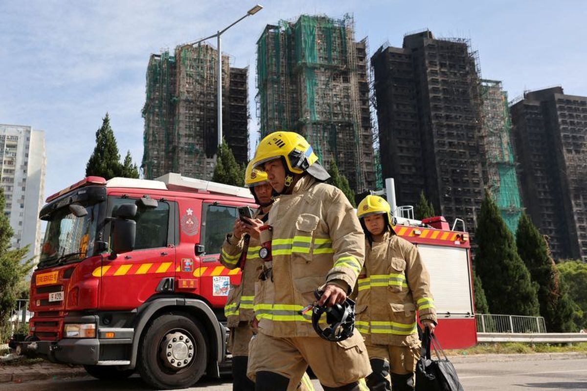 Firefighters walk near the site of a major fire at Wang Fuk Court housing complex, where flames engulfed bamboo scaffolding across multiple blocks, in Tai Po, Hong Kong, China, November 28, 2025. REUTERS/Tyrone Siu  (Tyrone Siu)