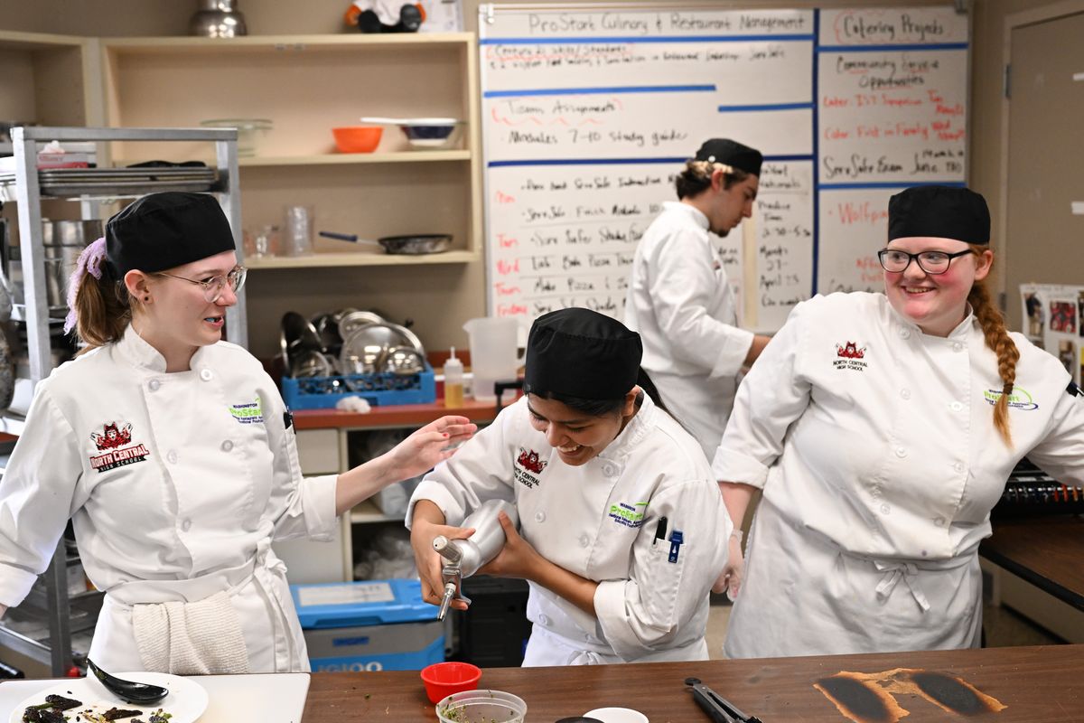 From left: Alisa Wilbur, Elina Khadka and Allison German laugh as the North Central seniors practice cooking after school on Thursday, Apr 11, 2024, at North Central High School in Spokane, Wash. North Central recently qualified at the state level to go the National ProStart Competition in Baltimore.  (Tyler Tjomsland/The Spokesman-Review)
