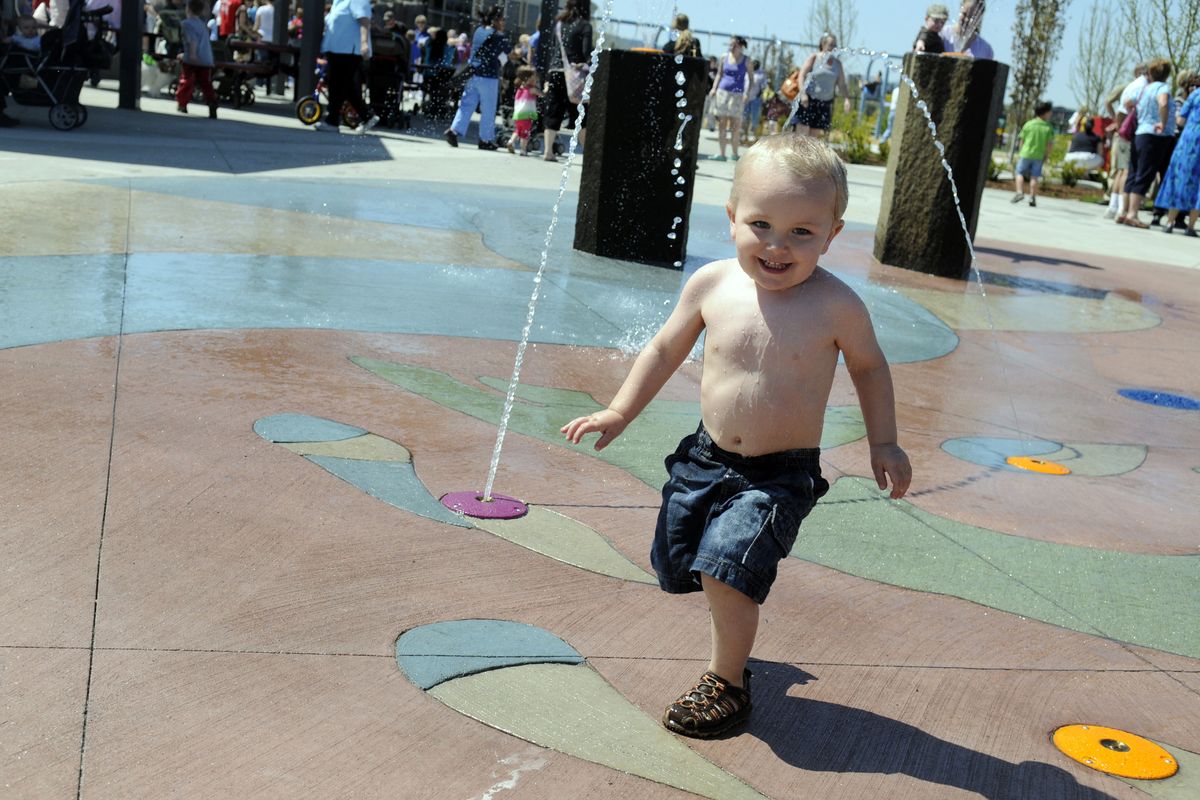 Taylor Brazeau, 21/2, frolics through the splash pad at the Discovery Playground in Spokane Valley on Thursday. (J. BART RAYNIAK)