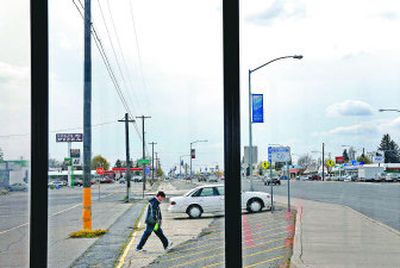 
As seen from the windows of a bus shelter, a pedestrian walks across the south side of the business strip in Airway Heights. The city is planning a landscape project to beautify the area. 
 (Holly Pickett / The Spokesman-Review)