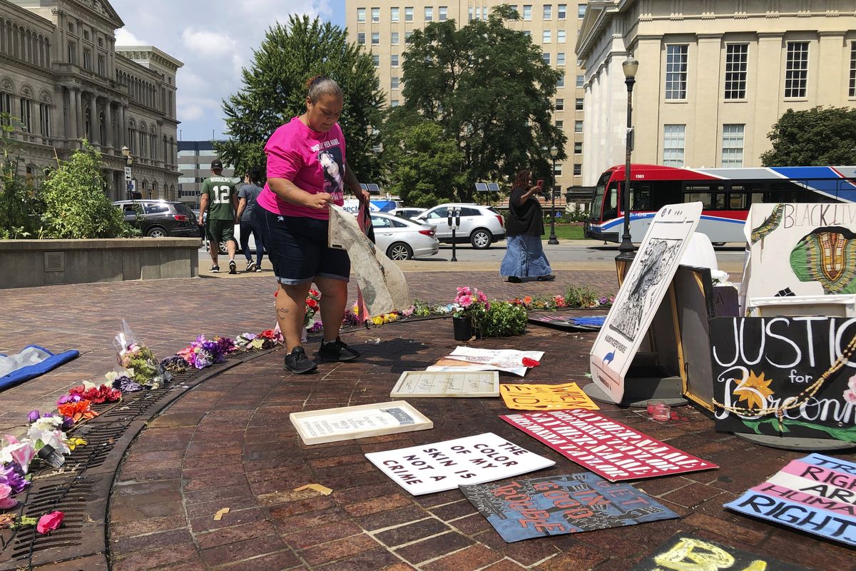 Amber Brown, a Louisville city bus driver, sets up Breonna Taylor artwork at a long-time protest site on Aug. 24 in Louisville, Ky.  (Dylan Lovan)