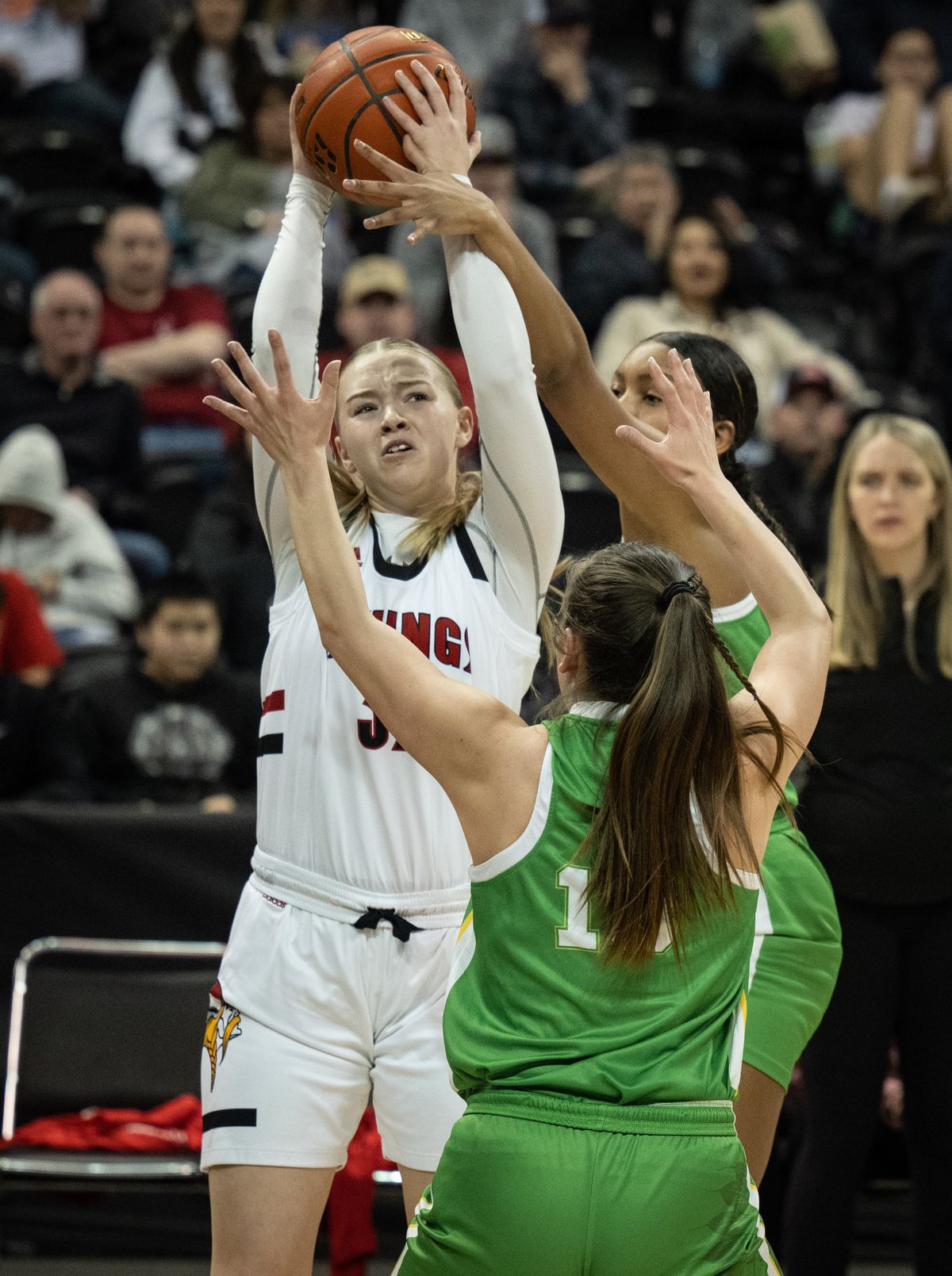 Mossyrock forward Hailey Brooks lines up a shot as Inchelium forward Alissa Finley (in back) and guard Torrence Finley defend during a WIAA State 1B high school basketball game, Friday, March 3, 2023, in the Spokane Veterans Arena.  (COLIN MULVANY)