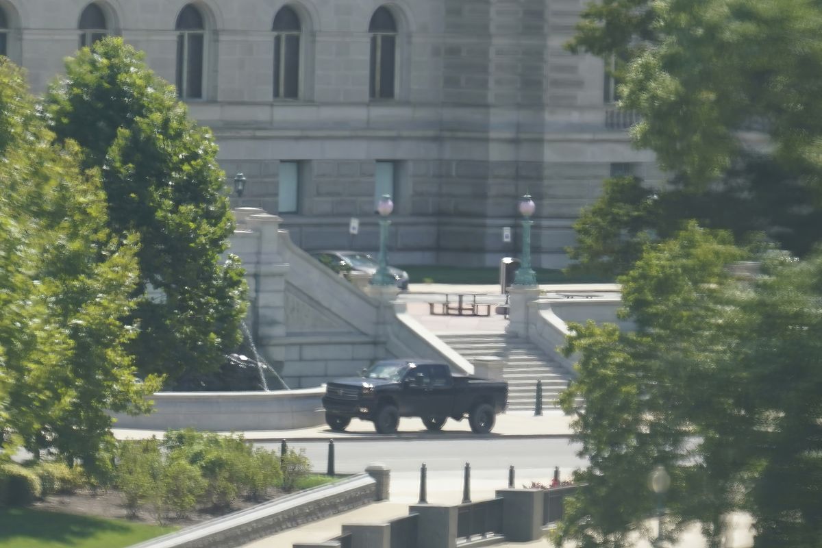 A pickup truck is parked on the sidewalk in front of the Library of Congress