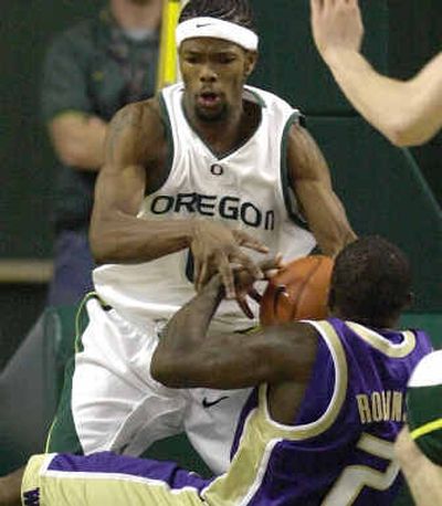 Oregon's Aaron Brooks battles for the ball with Washington's Nate Robinson, who takes a tumble. Robinson led all scorers with 24 points.
 (Associated Press / The Spokesman-Review)