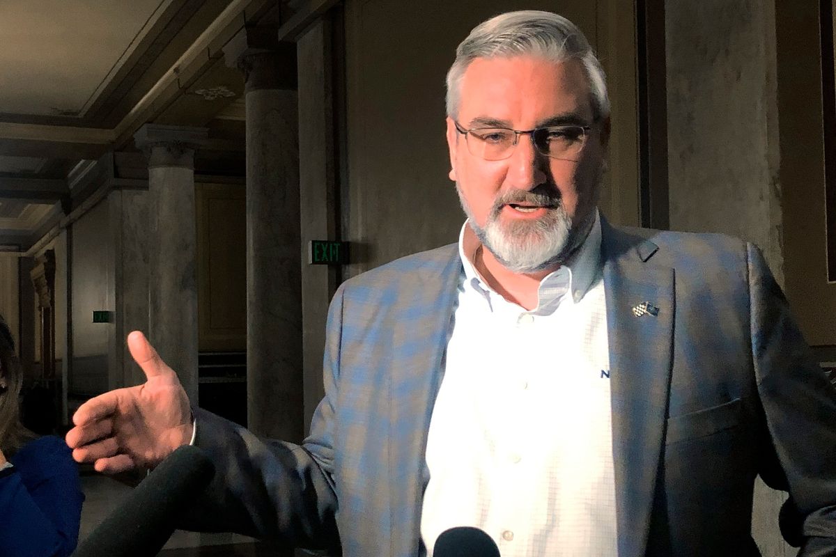 Indiana Gov. Eric Holcomb speaks with reporters at the Indiana Statehouse in Indianapolis on Wednesday, Feb. 23, 2022. The Republican governor signaled support for contentious proposals moving through the Legislature that would ban transgender girls from participating in K-12 girls school sports and would place restrictions on teaching about racism and political topics.  (Tom Davies)