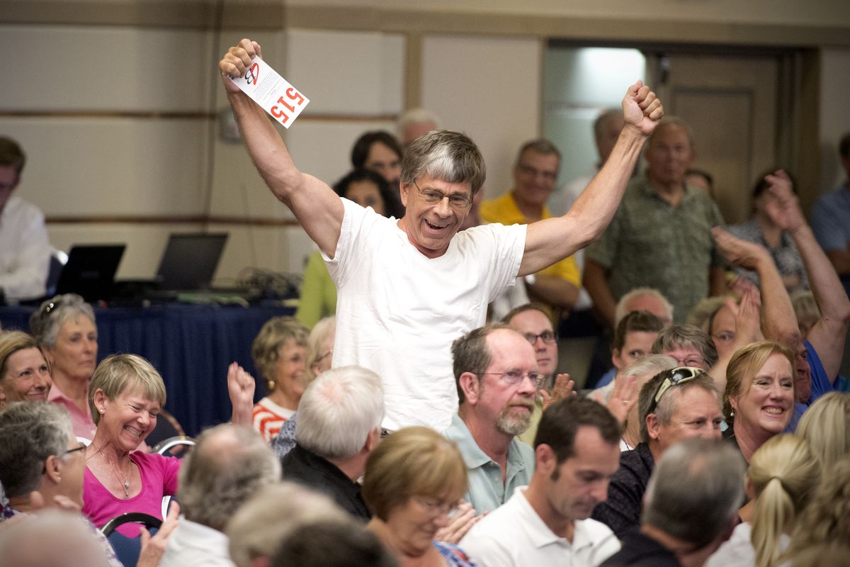 Tom Wielgos celebrates after entering the winning bid for the Priest Lake site where he has a home on Thursday. His was the only bid on the property during the auction at the Coeur d’Alene Resort. The state of Idaho auctioned long-leased sites, many with cabins or houses on them. In most cases cabin owners bought the land under their rural vacation homes. (Jesse Tinsley)