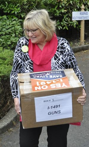 OLYMPIA -- Washington First Lady Trudi Inslee carries a carton of petitions for Initiative 1491, a gun control proposal, to the state elections office on July 7, 2016, as supporters announced they were turning in 330,000 signatures for the measure. (Jim Camden/The Spokesman-Review)