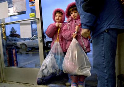 
Kaytlyn, 7, left and Alexyn Brenneman, 5, brought last year's snow clothes to St Vincent DePaul's Thrift Store in Post Falls earlier this month. Their parents, Matt and Carletta Brenneman, take their kids each year to donate the previous year's snow wear to charity. 
 (Kathy Plonka / The Spokesman-Review)