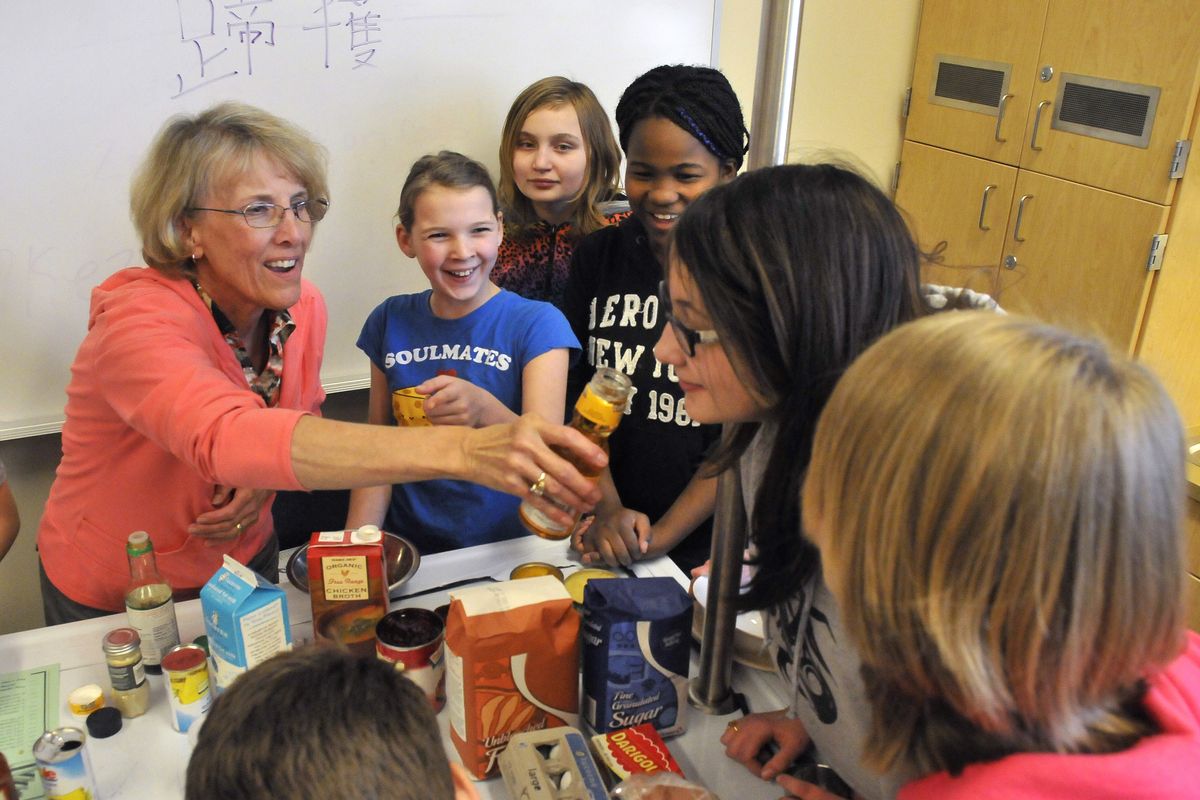Teacher Diane Turbeville, left, gives her middle school students a sniff of rice wine vinegar Wednesday at Cheney Middle School. In an after-school enrichment program, youngsters were measuring ingredients for Hawaiian barbecued chicken. (Jesse Tinsley)