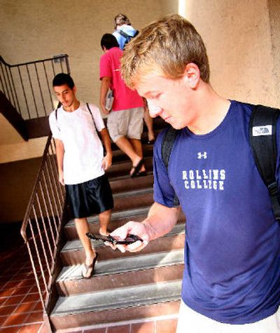 
Rollins College student Steve Miller checks text messages on his phone in Winter Park, Fla. As the novelty of their wired lives wears off, young people also are getting more sophisticated about the way they use such tools as social networking and text and instant messaging, not just constantly using them because they're there. 
 (Associated Press / The Spokesman-Review)