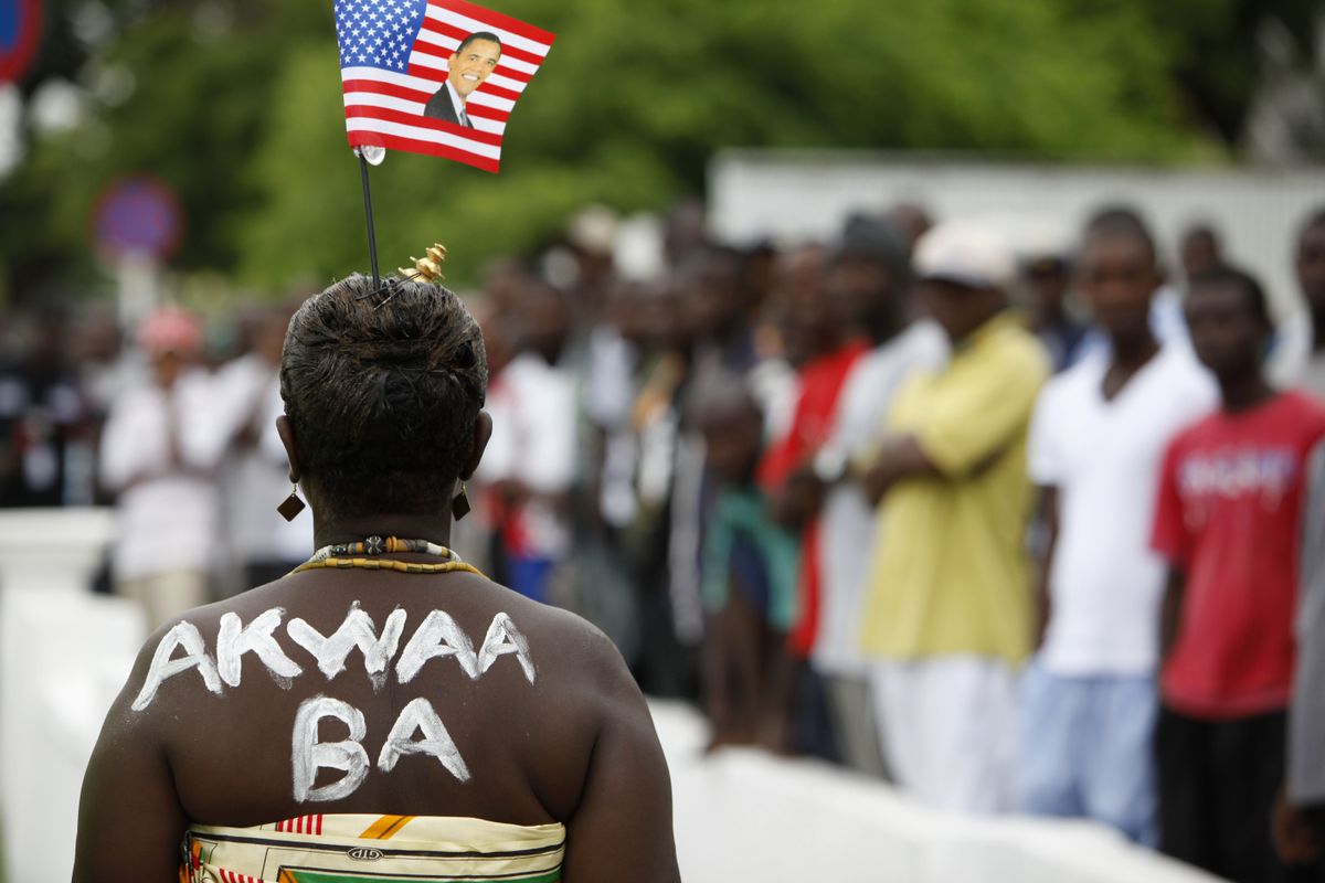 A Ghanaian woman wears  an Obama-printed flag and paint saying “Welcome” as she waits for the arrival of Obama’s convoy  Saturday at the Presidential Palace. (The Spokesman-Review)