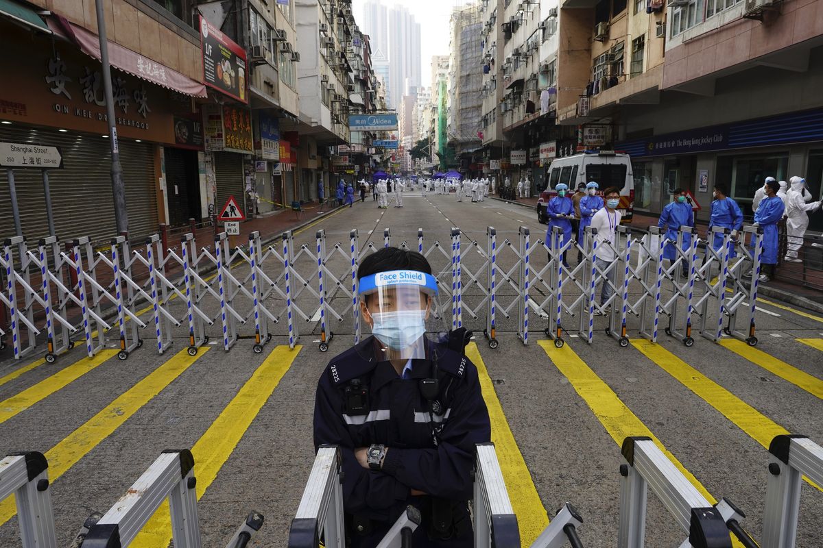 A police officer stands guard at the Yau Ma Tei area, in Hong Kong, Saturday, Jan. 23, 2021. Thousands of Hong Kong residents were locked down Saturday in an unprecedented move to contain a worsening outbreak in the city, authorities said.  (Vincent Yu)