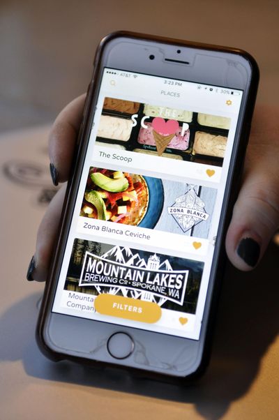 Jennifer Davis, owner of The Scoop ice cream shop on Spokane’s South Hill, shows off the newly launched app she created. (Adriana Janovich / The Spokesman-Review)