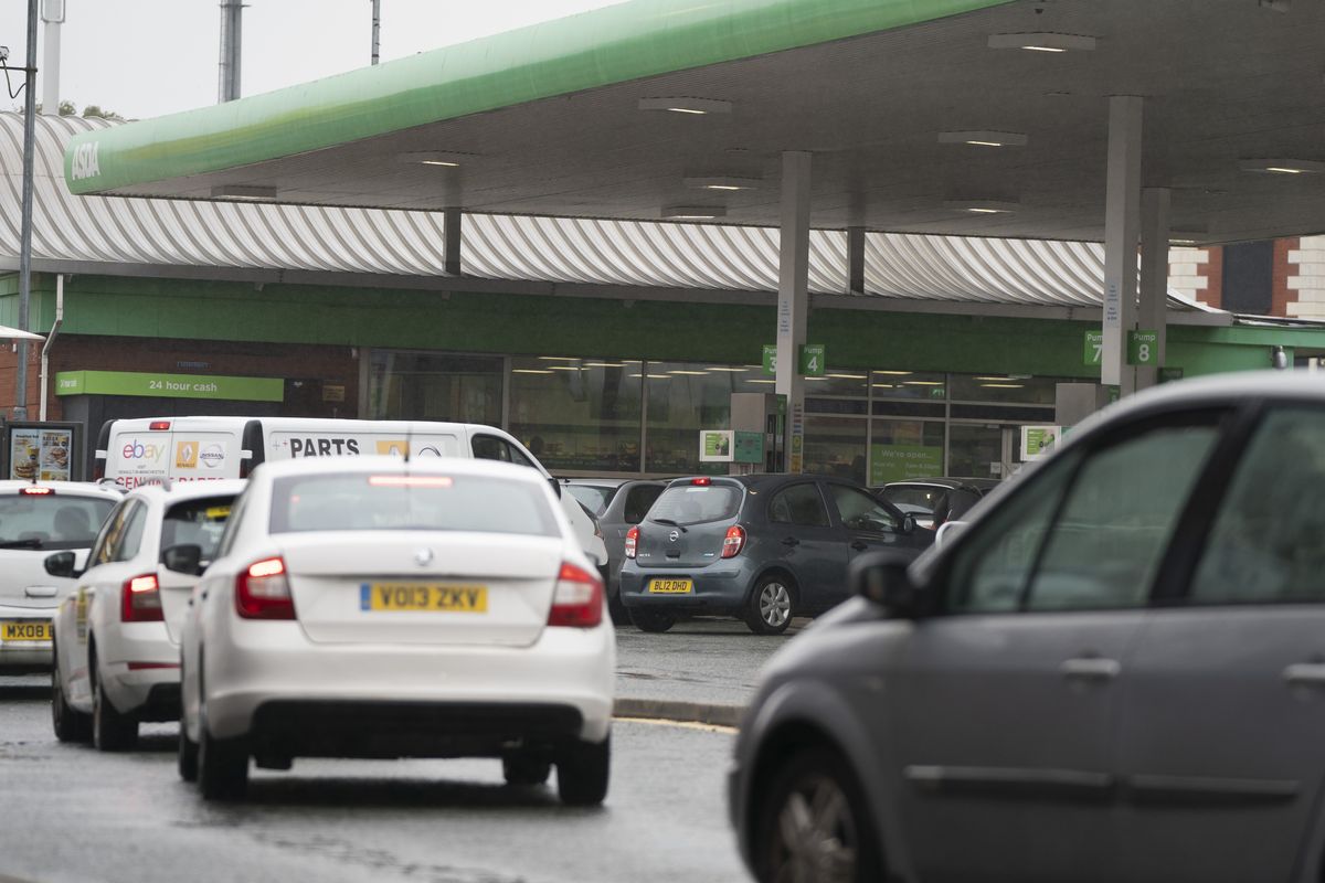 Vehicles wait to fill up at a petrol station in Manchester, England, Monday, Sept. 27, 2021. British Prime Minister Boris Johnson is said to be considering whether to call in the army to deliver fuel to petrol stations as pumps ran dry after days of panic buying.  (Jon Super)