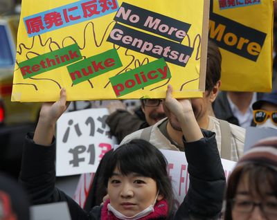 A protester holds a placard during an anti-nuclear rally in Tokyo on Sunday. (Associated Press)