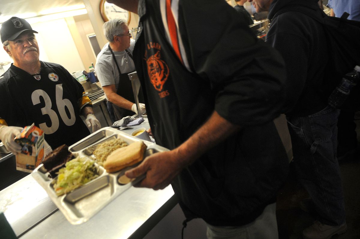Volunteer Patrick Sloper serves lunch to men and women at the House of Charity  on Tuesday.  (Rajah Bose / The Spokesman-Review)