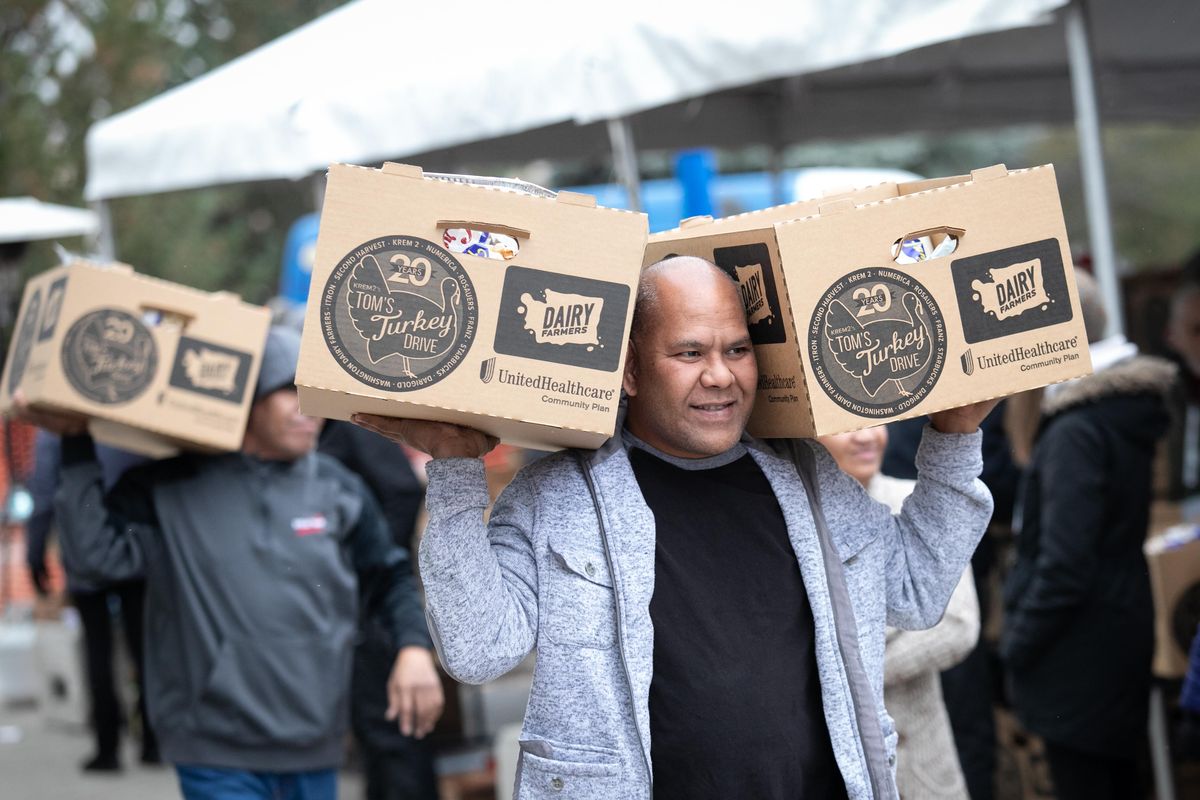 Ali Jilon carries meals in boxes during the 20th annual Tom