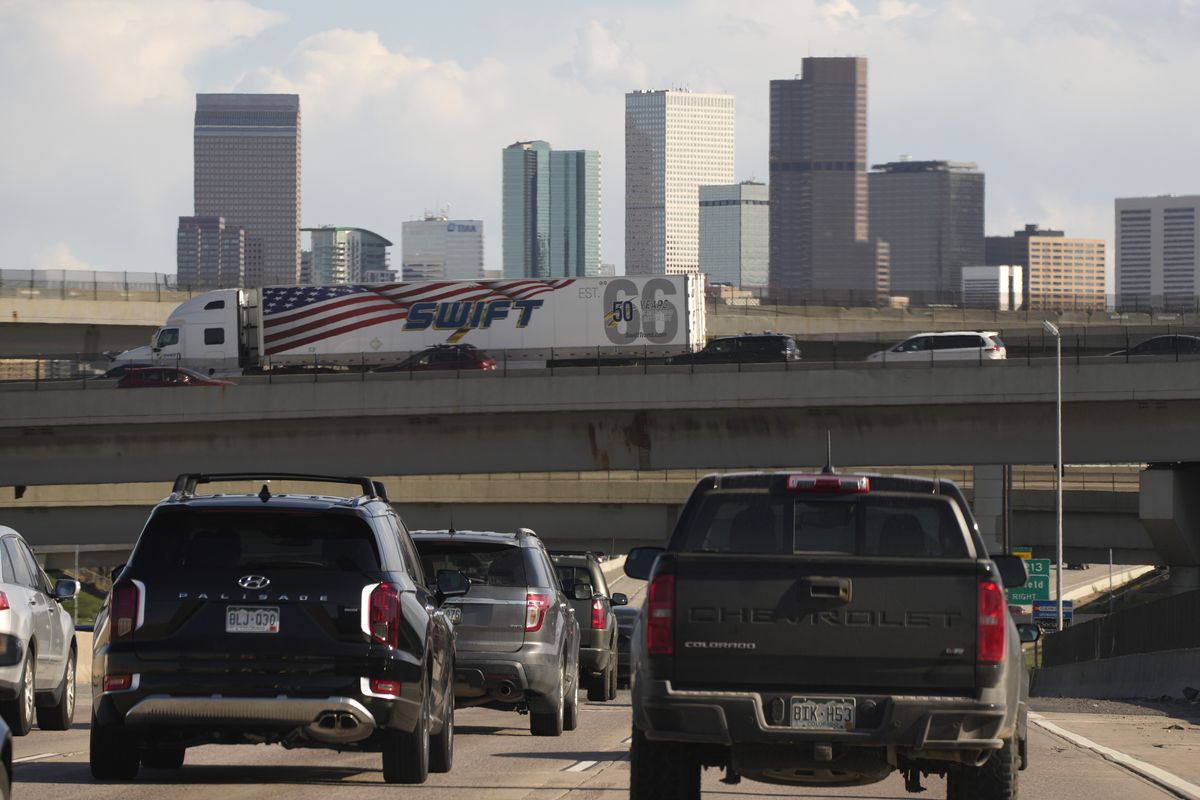 FILE – In this May 27, 2021 file photo, vehicles move along southbound Interstate 25 while motorists sit on the Interstate 70 overpass to start the Memorial Day weekend in Denver. Americans were hitting the road in near-record numbers at the start of the holiday weekend. More than 1.8 million people went through U.S. airports on Thursday, and that number could top 2 million over the weekend, the highest mark since early March of last year.  (David Zalubowski)