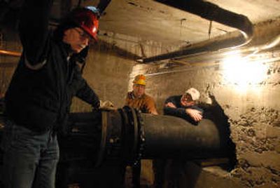 
City water workers  Tom Leonard, Bert Cheney and Mike Wilhelm, from left, stand in the basement room of the water pumping station where two other water workers were trapped in October when a pipe broke and flooded the basement area in just a few seconds. 
 (Jesse Tinsley / The Spokesman-Review)