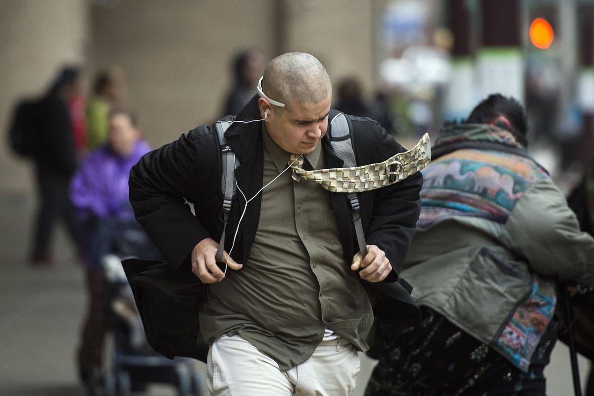 Zach Trujillo battles the high winds as he catches a bus, Nov. 17, 2015, at the STA Plaza in downtown Spokane, Wash. (Dan Pelle / The Spokesman-Review)