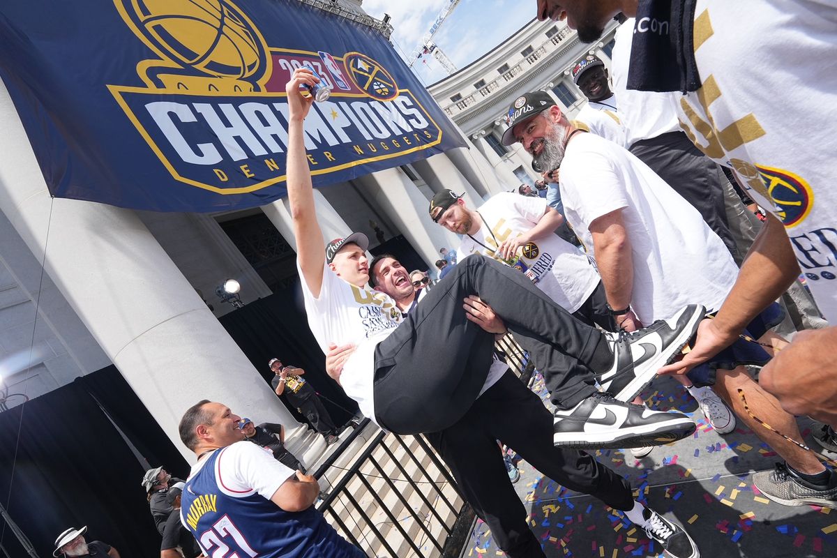 Former Gonzaga walk-on Connor Griffin picks up center Nikola Jokic during the team’s championship parade in downtown Denver on June 15.  (Courtesy/Bart Young)