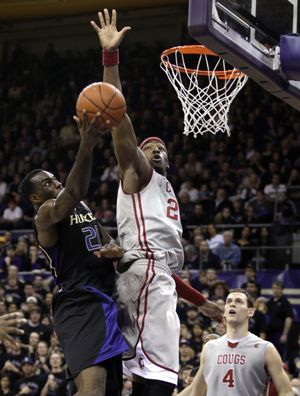 Washington forward Quincy Pondexter, left, drives to the basket as Washington State forward DeAngelo Casto defends and Washington State's Nikola Koprivica (4), of Serbia, looks on in the first half of an NCAA college basketball game, Saturday, Jan. 30, 2010, in Seattle. (Ted Warren / Associated Press)