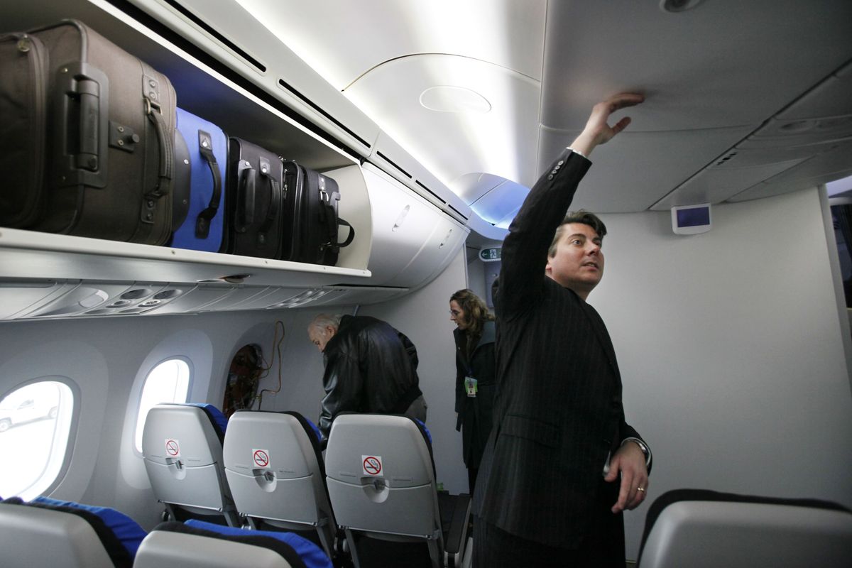 Kent Craver, Boeing Co.'s regional director for passenger satisfaction and revenue, shows off the headroom in the passenger cabin of the first Boeing 787 with the interior installed at the production plant in Everett, Wash., Wednesday, Feb. 3, 2010. (Elaine Thompson / Associated Press)