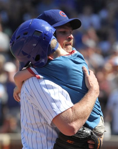 Chicago Cubs relief pitcher Kerry Wood hugs his son, Justin, after being taken out of his final game. (GEORGE LECLAIRE)