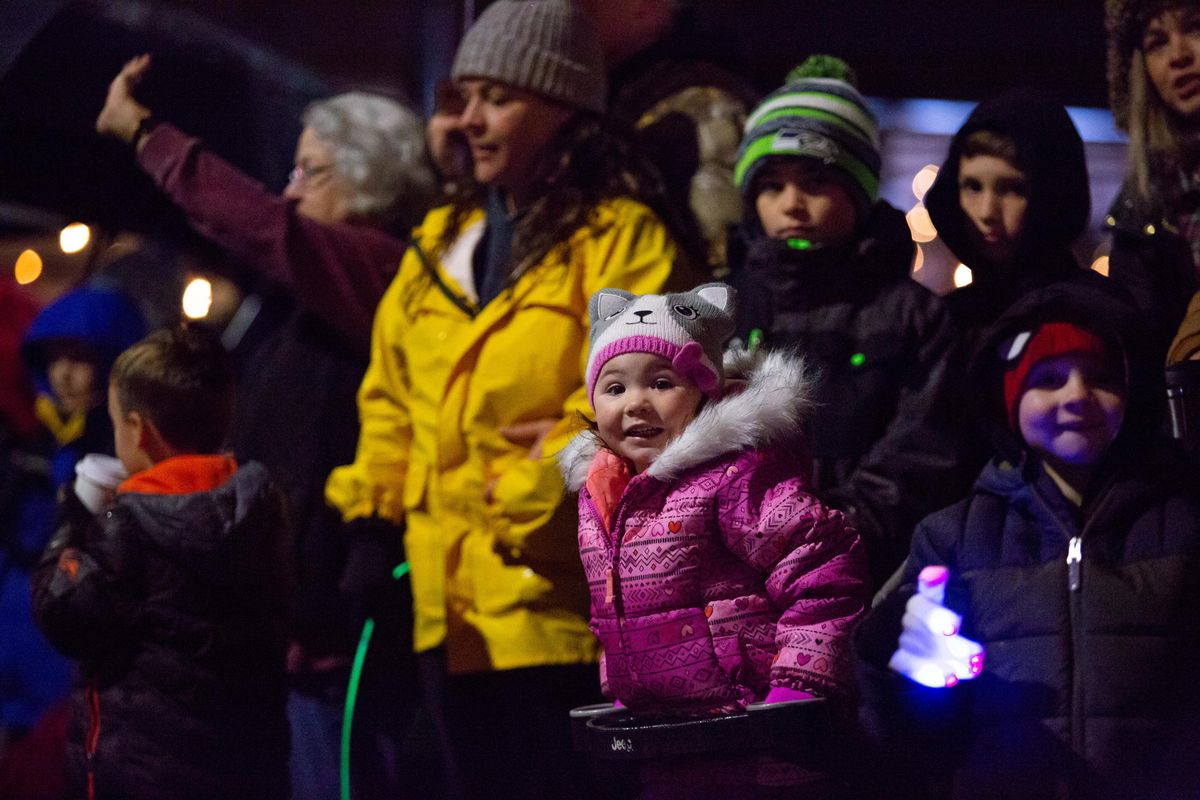 Adalie Corcoran, age 2, looks excitedly onward toward the annual lighting ceremony parade Saturday on Sherman Avenue in  Coeur d’Alene. (Libby Kamrowski / The Spokesman-Review)
